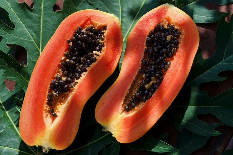 Two papaya halves show their seedy interiors. If you're wondering "is my vagina normal," rest assure...