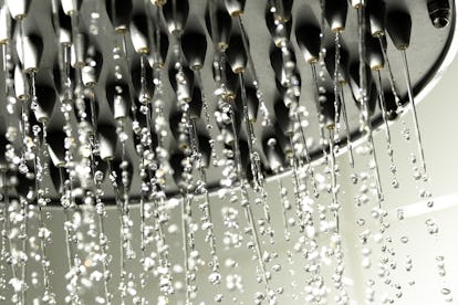 A showerhead with water streaming down. Taking a shower can help you clean off after sex, if that's ...