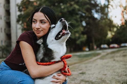 A woman looks happy with her dog. Gratitude can improve health outcomes, mental health and our conne...