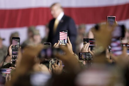 Blurred Donald Trump walking and people taking photos of him on their mobile phones