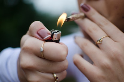 A woman lights a joint. A weird feeling in chest when high can be an effect of getting stoned.