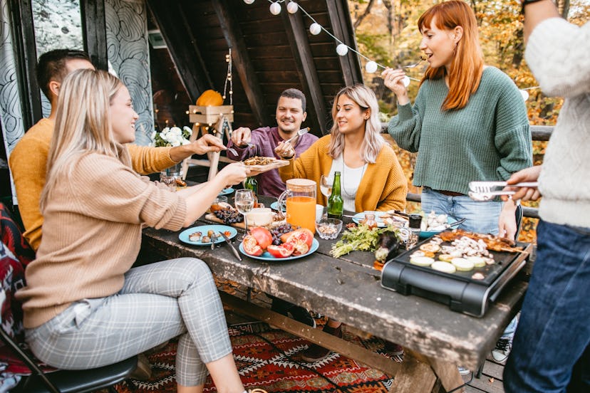Friends eat a Thanksgiving meal outdoors. A sober Thanksgiving event can be great fun with the prope...