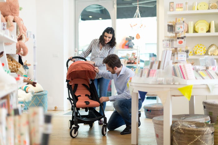 a pregnant woman and her partner shopping for strollers