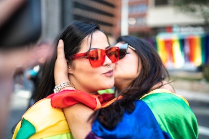 A lesbian couple kissing on the cheek
