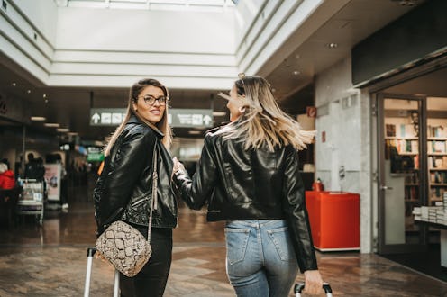 Two women walk in an airport. Many surfaces in airports can carry flu germs in cold and flu season.