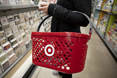 A woman holding a target grocery basket in a book aisle