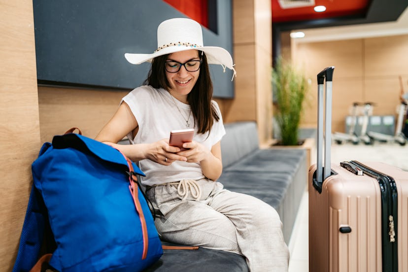 A woman carries two bags in an airport. Luggage can carry a lot of flu germs in autumn and winter. 