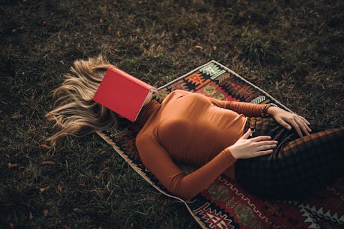 A woman sleeps under a book. The brain needs sleep to operate properly, and not just because it's ti...