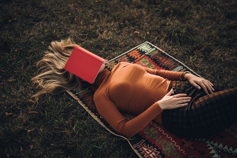 A woman sleeps under a book. The brain needs sleep to operate properly, and not just because it's ti...