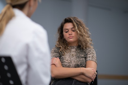 Curly blonde girl having a conversation about addiction with her doctor