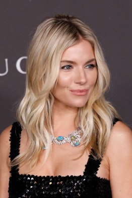 Sienna Miller at LACMA with her hair down, in a black sequin dress and a Gucci necklace with turquoi...