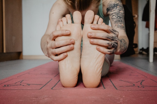 A person does yoga on a mat.