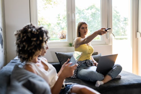 Roommates watch tv on couch. Marathoning TV is linked to anxiety, but why not just let people enjoy ...