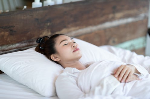 Woman sleeping in bed, listening to white noise.