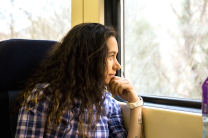 A woman staring out the window of a train, traveling home for the holidays. Nosy relatives are an in...