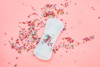 A menstrual pad covered with sprinkles. Losing your period can be a sign of low estrogen.