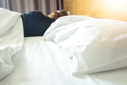 A woman lying on her side in bed. Loss of libido can be a  sign of low estrogen.