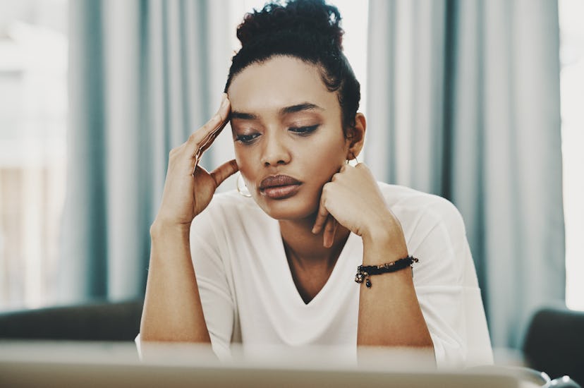 A woman looks tired at work. Burnout can thin the prefrontal cortex, impairing decision-making, memo...