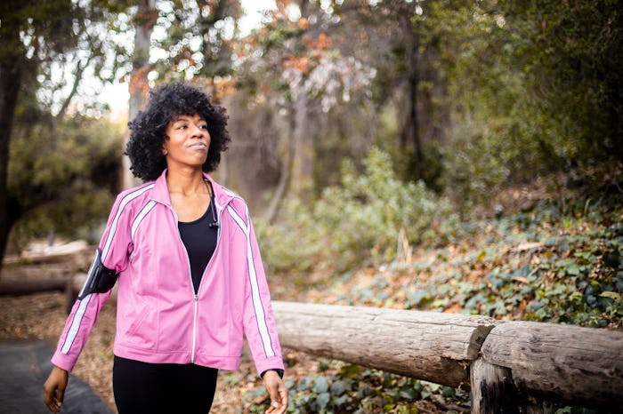 a woman walking through a trail in the woods