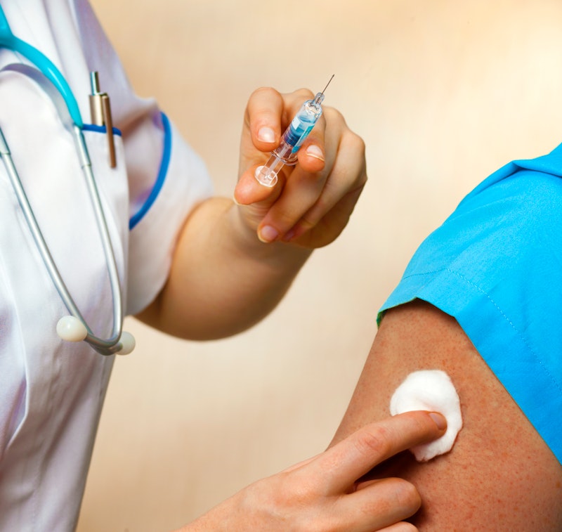 A medical professional prepares to give a patient a flu shot. Getting your flu shot might be especia...