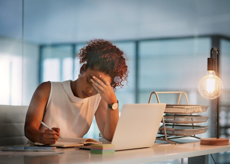 A woman sits at a desk doing work. A new report says it'll take another 257 years to close the gende...