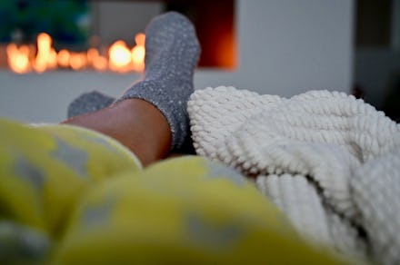 A man relieving stress while lying in his bed covered with a yellow blanket