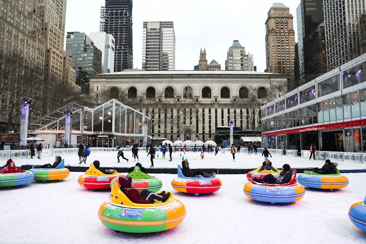 Travelers ride around in bumper cars on ice during FrostFest in Bryant Park in New York City.