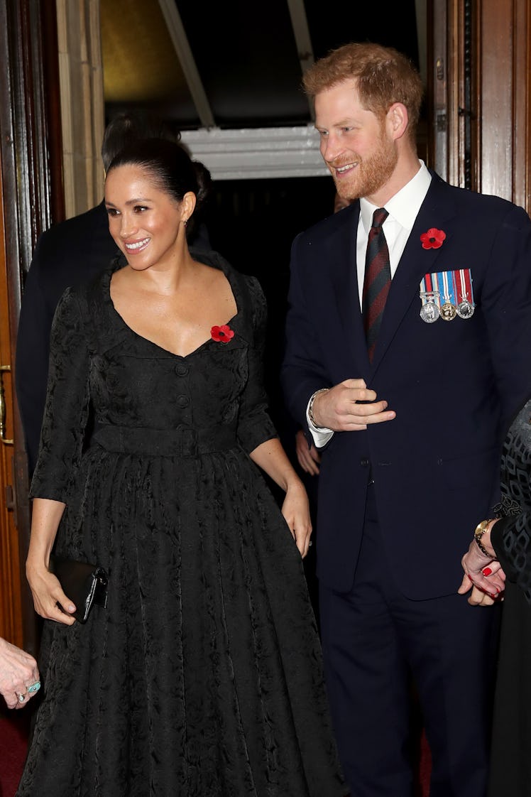 Meghan Markle and Prince Harry flash smiles for the camera.