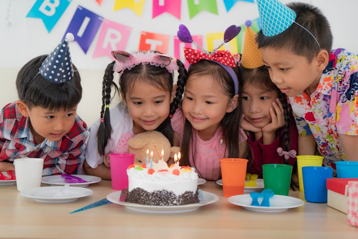 a group of kids at a birthday party with a cake