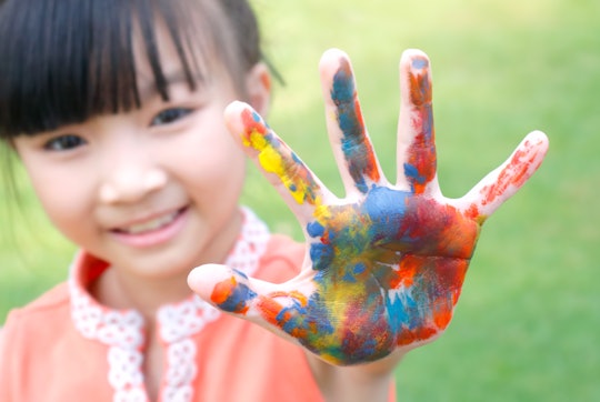 a little girl with paint all over the palm of her hand