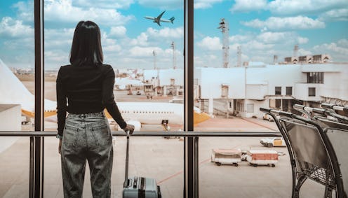 A woman waits to board her plane. Boarding your plane before your zone is called is generally a no-n...