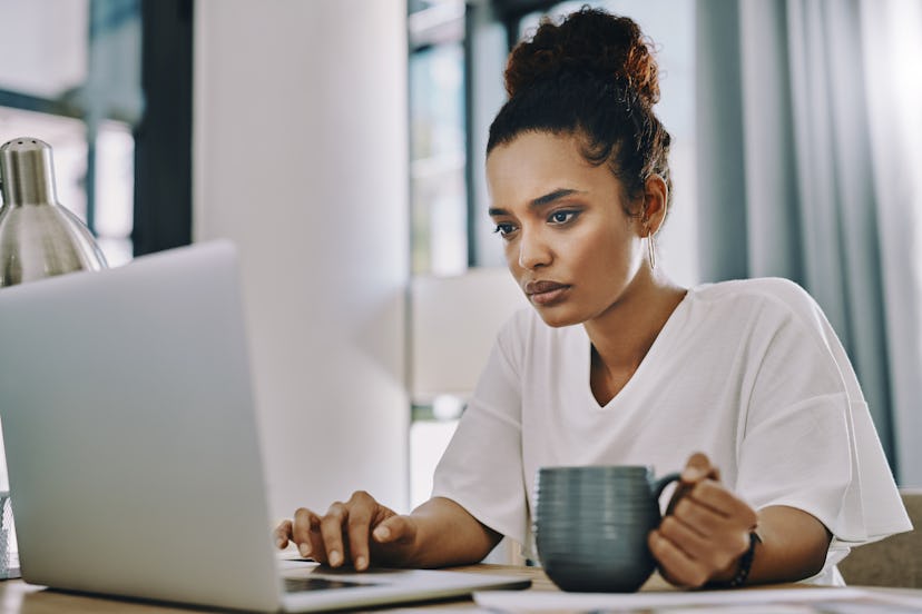 woman working on laptop and drinking coffee
