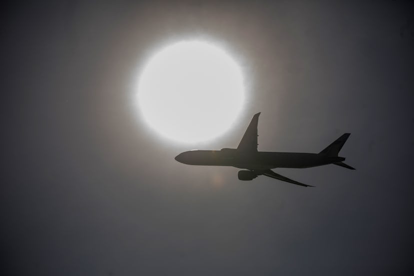 A plane flies across the sun. Air travel can cause a significant amount of damage to air quality and...