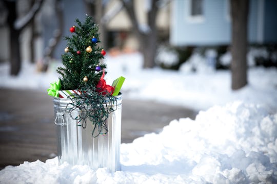 an artificial Christmas tree in the garbage