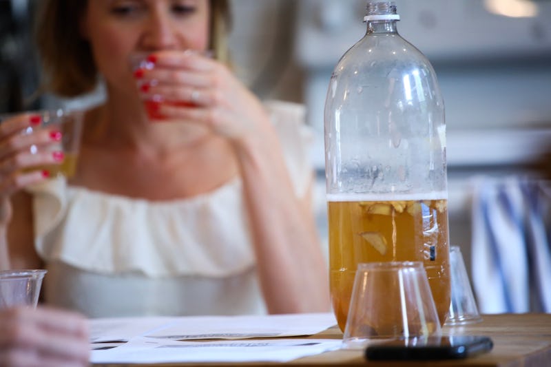 A woman drinks kombucha. Kombucha can be a delicious alternative to alcohol. 