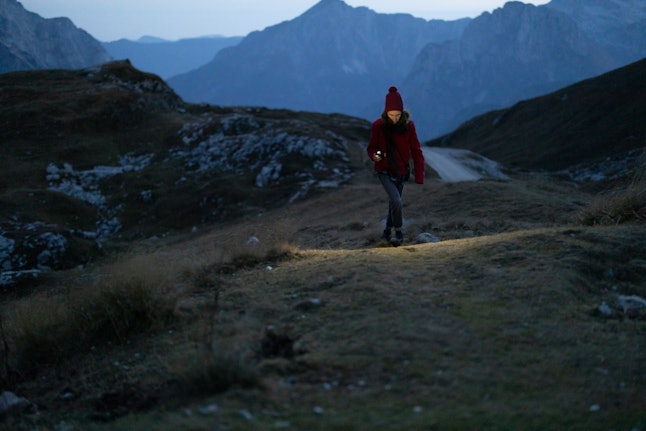 A woman walks in a dark winter landscape. Darker mornings in winter may contribute to SAD, or seasonal affective disorder. 