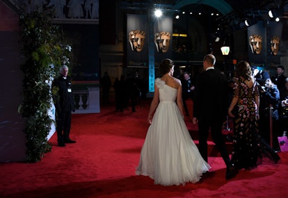 Kate Middleton entering the BAFTAs wearing a white bold, one-shoulder dress 