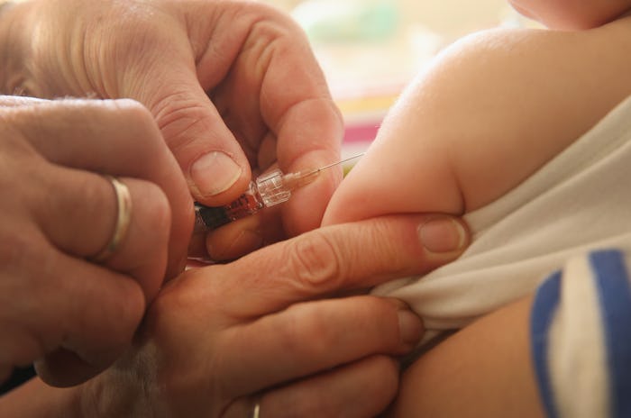 A kid getting a vaccine shot from a doctor