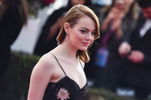 Emma Stone wearing a satin floral dress on a red carpet