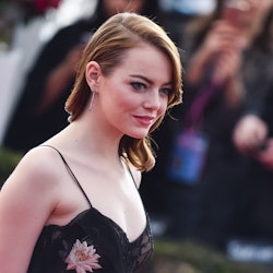 Emma Stone wearing a satin floral dress on a red carpet