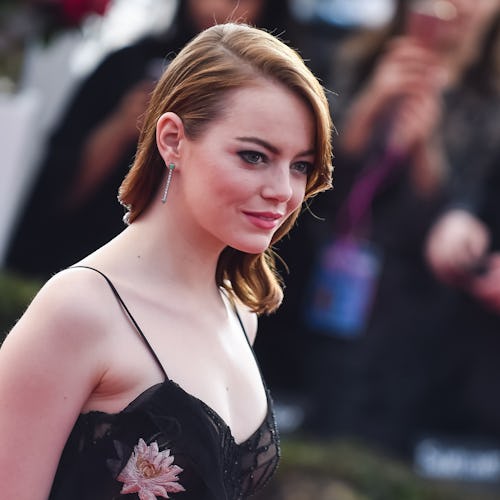 Emma Stone wearing a satin floral dress on a red carpet