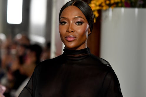 Naomi Campbell in a sheer black shirt attending Paris fashion week