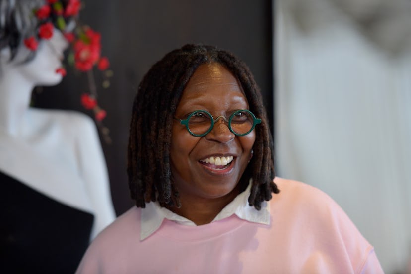 Whoopi Goldberg laughing in a pink sweater