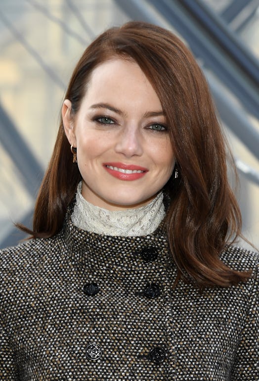 Emma Stone with a smoky eye look, smiling for a photo