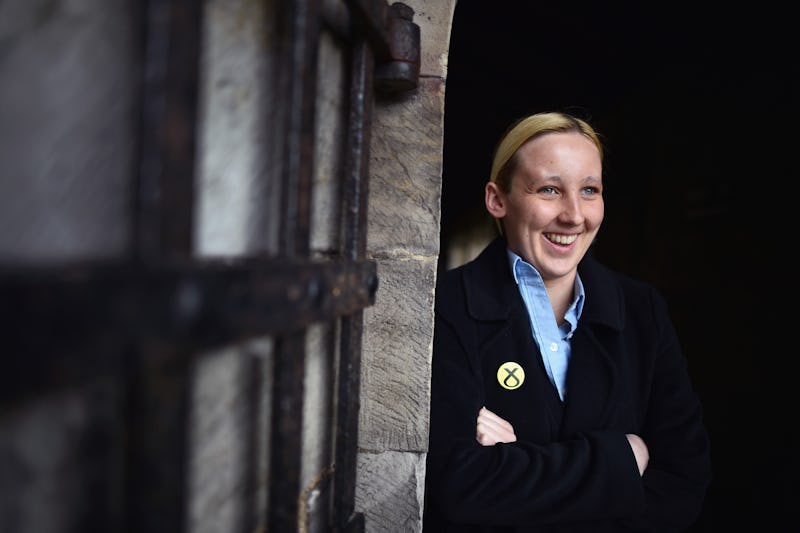 Female MP in Parliament wearing a suit and smiling for a photo