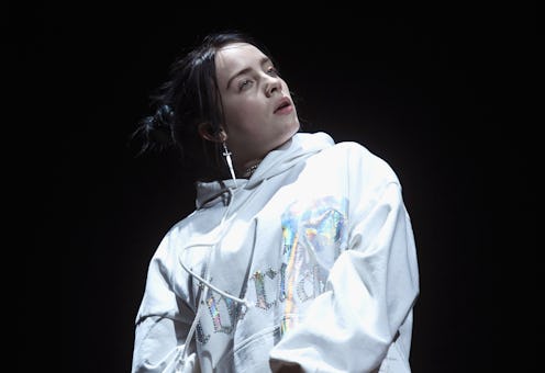 Billie Eilish live on stage in a white track suit
