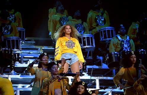 Beyonce wearing a yellow hoodie and blue shorts on her concert