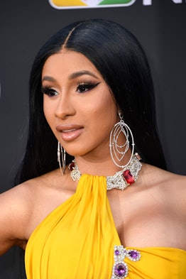 Close up of Cardi B wearing a yellow halter neck dress at the Billboard Music Awards red carpet.
