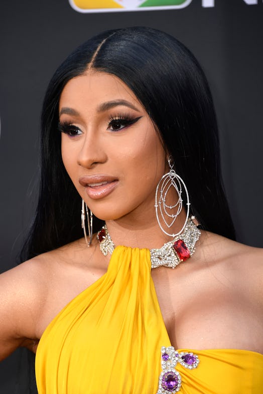 Close up of Cardi B wearing a yellow halter neck dress at the Billboard Music Awards red carpet.