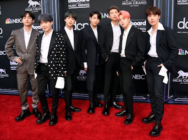 BTS on the red carpet all wearing similar black tuxedos